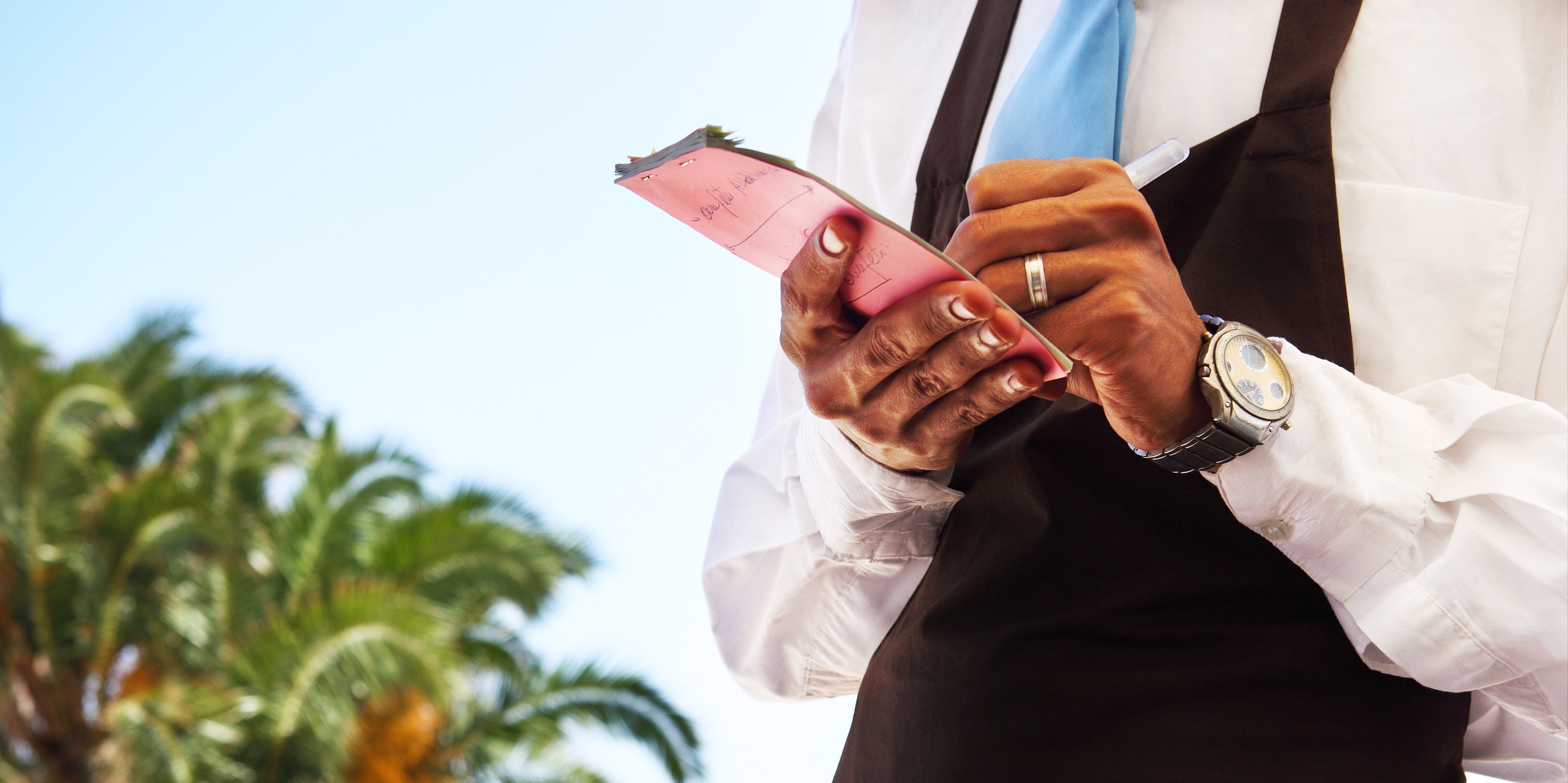 waiter writing on carbonless paper that is coated with Impermea Materials cationic barrier coating